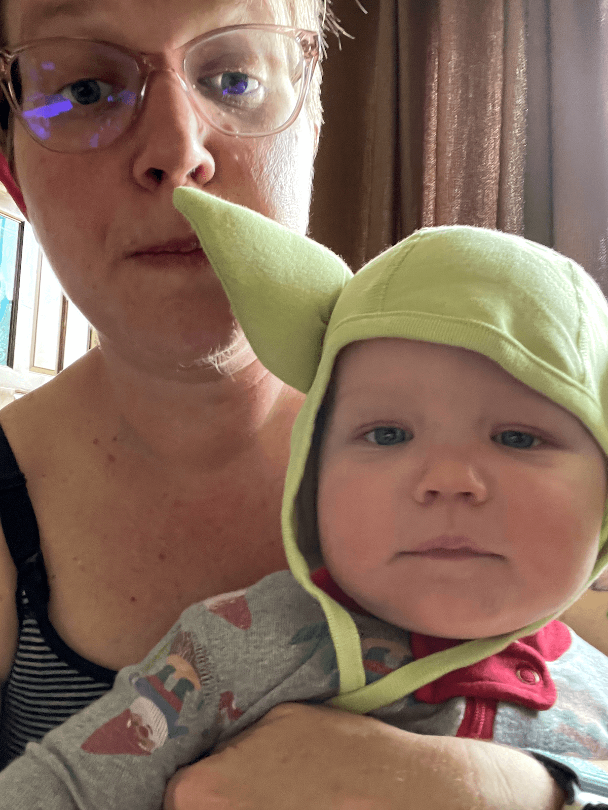 Photo of me behind my baby wearing a yoda hat.